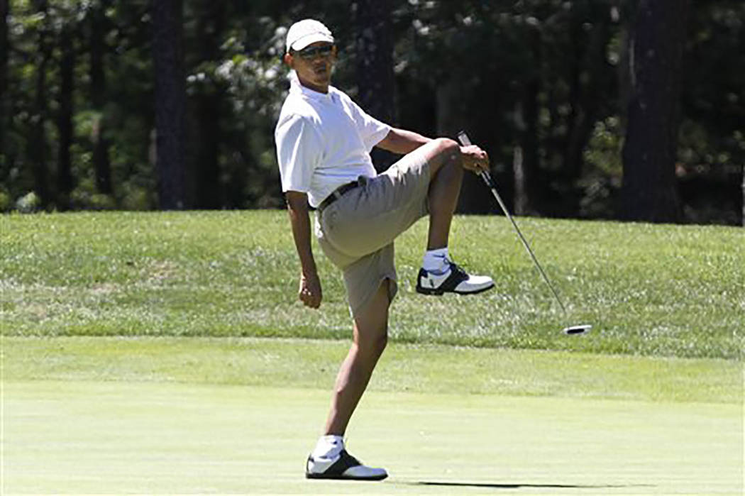 President Barack Obama reacts as he misses a shot while golfing on the first hole at Farm Neck ...