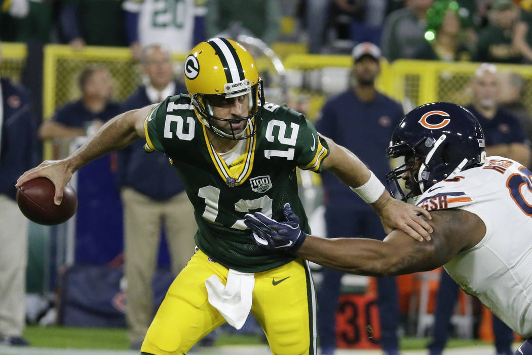 Green Bay Packers' Aaron Rodgers gets away from Chicago Bears' Akiem Hicks during the first hal ...