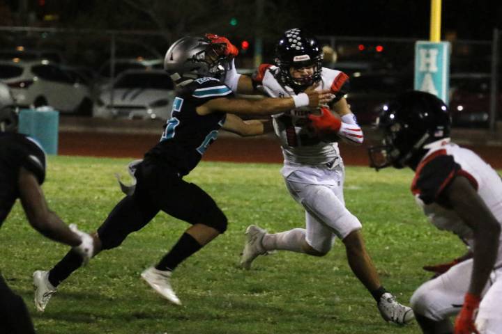 Las Vegas High's wide receiver Dalten Silet (13) avoids a tackle from Silverado High's Jeremy A ...