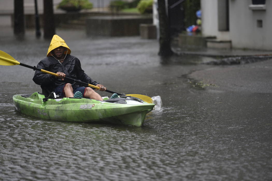 Johnny Crawford navigates his kayak down a flooded street, Thursday, Sept. 5, 2019, in Charlest ...