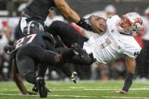 UNLV quarterback Armani Rogers (1) is brought to the ground by Arkansas State linebacker Caleb ...