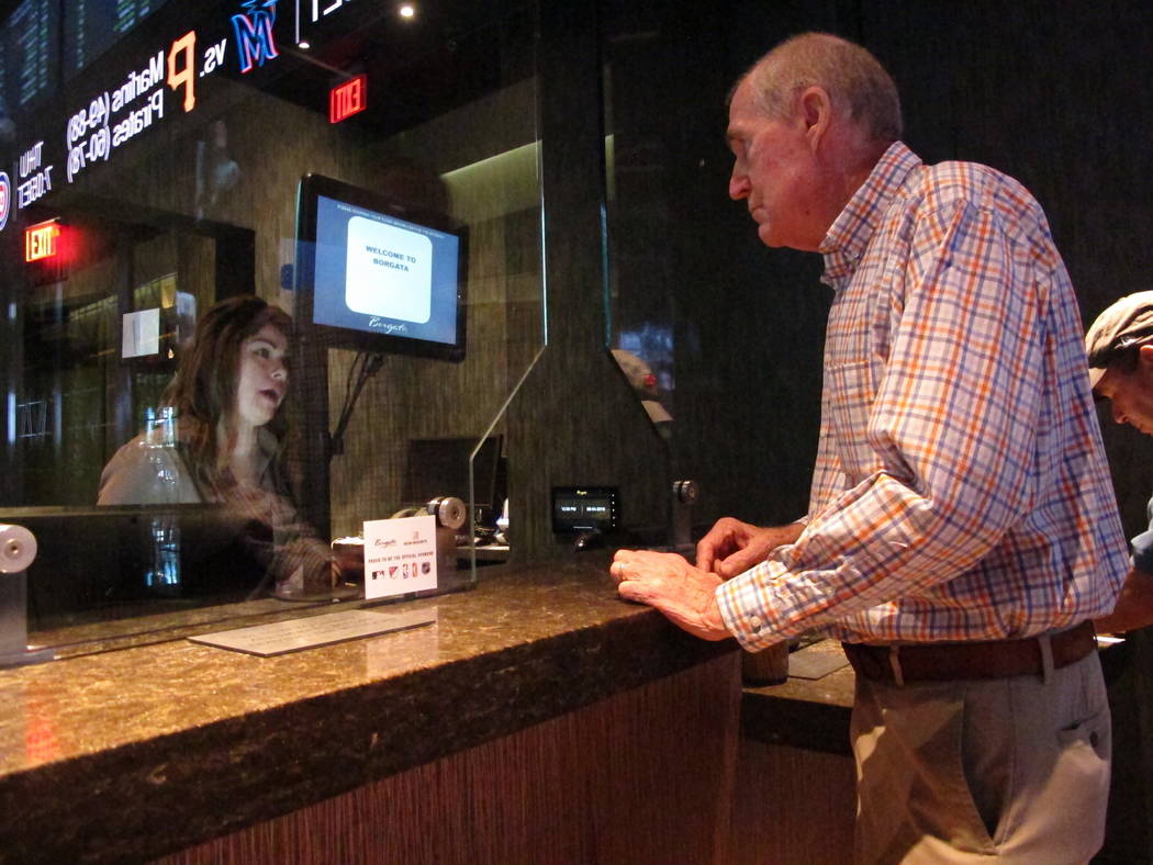 This Sept. 4, 2019 photo shows a customer checking the odds at the sports book at the Borgata c ...