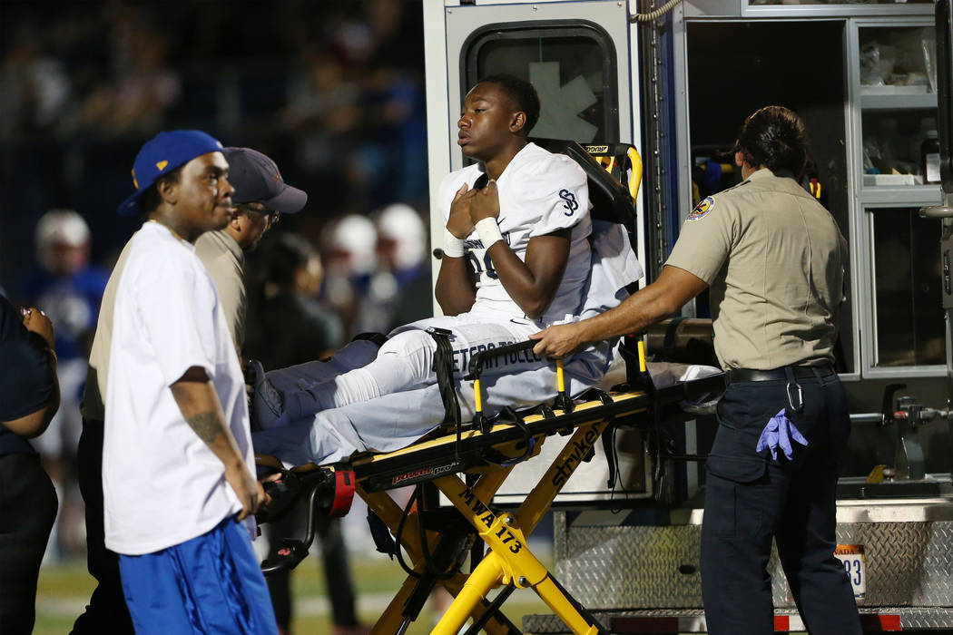 St. John Bosco's Michael Hayes (28) receives medical attention after a play against Liberty in ...