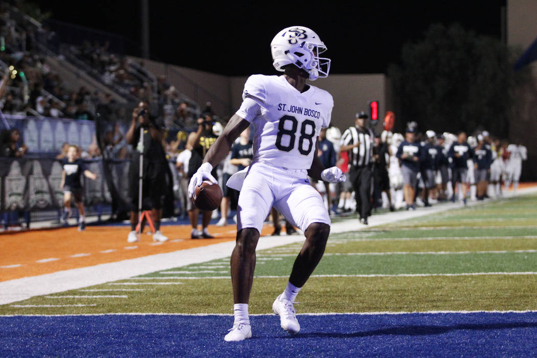 St. John Bosco's Beaux Collins (88) looks back after scoring a touchdown against Liberty in the ...