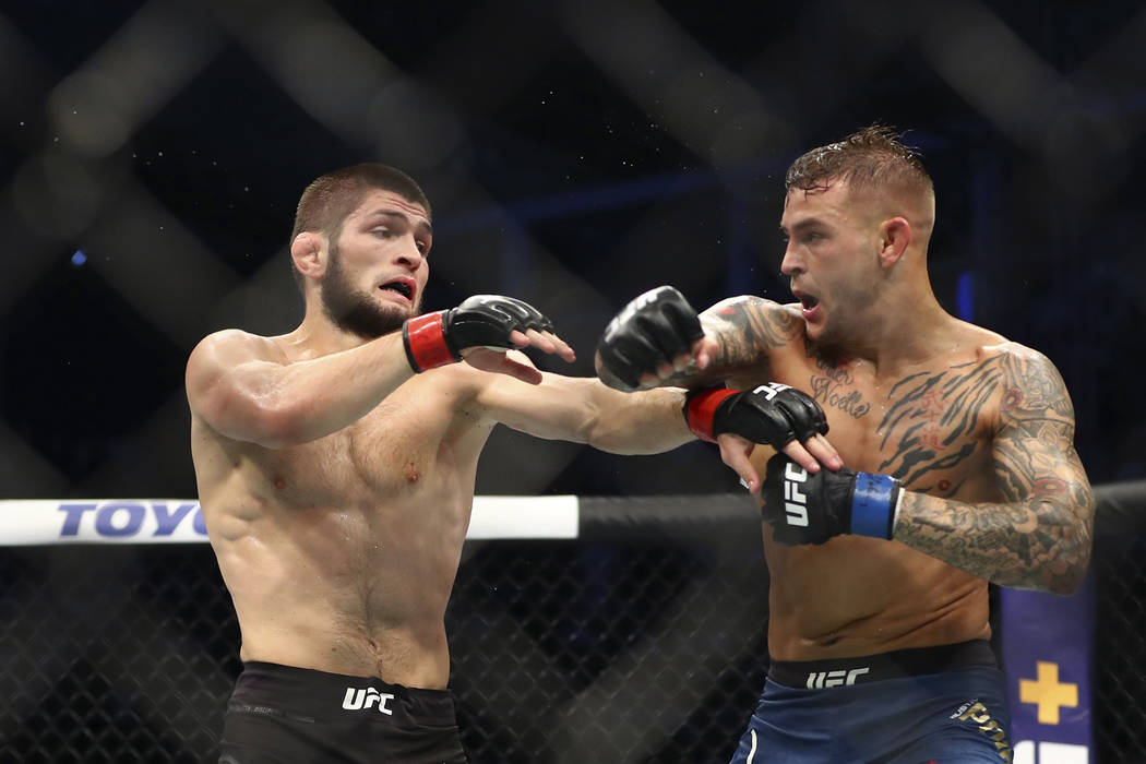 Russian UFC fighter Khabib Nurmagomedov, left, fights with UFC fighter Dustin Poirier, of Lafay ...