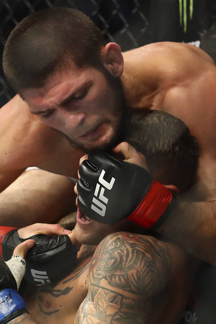 Russian UFC fighter Khabib Nurmagomedov, top, fights with UFC fighter Dustin Poirier, of Lafaye ...
