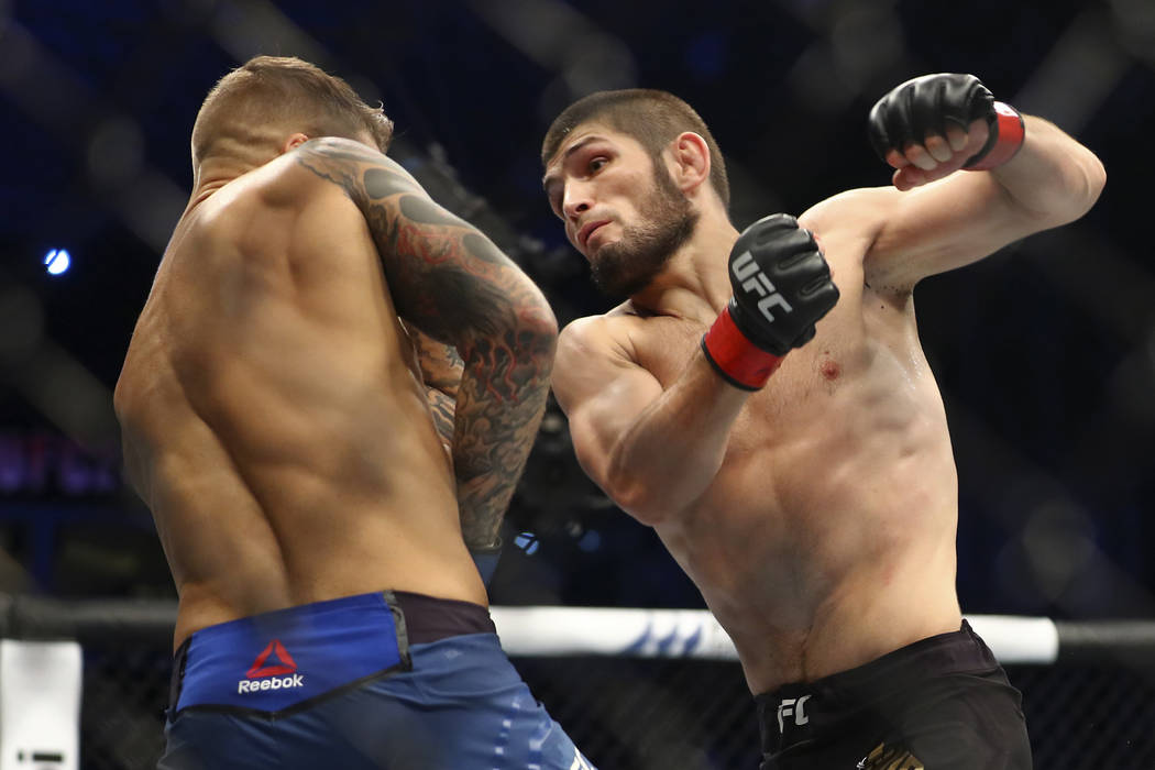 Russian UFC fighter Khabib Nurmagomedov, right, fights with UFC fighter Dustin Poirier, of Lafa ...