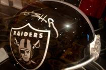 A modified, all-black helmet with a Raiders' logo and signed by Antonio Brown is shown at the a ...