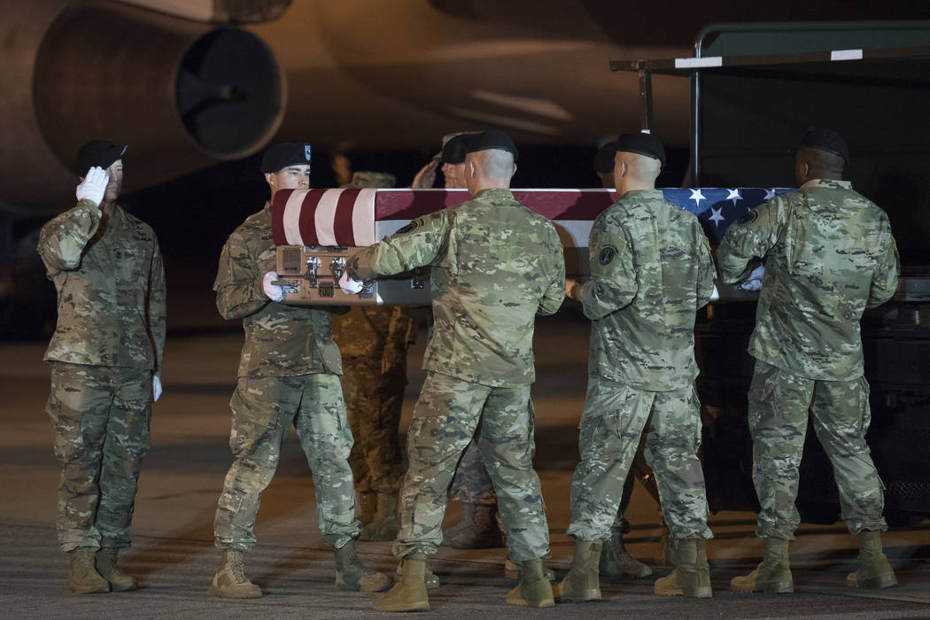 An Army carry team moves a transfer case containing the remains of Sgt. 1st Class Elis Barreto ...