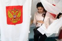 A woman exits a polling booth before casting at a polling station during a city council electio ...