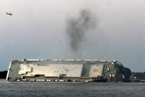 Smoke rises from a cargo ship that capsized in the St. Simons Island, Georgia sound Sunday, Sep ...