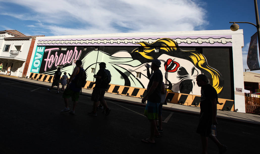 Attendees pass by a mural during the Life is Beautiful festival in downtown Las Vegas on Saturd ...