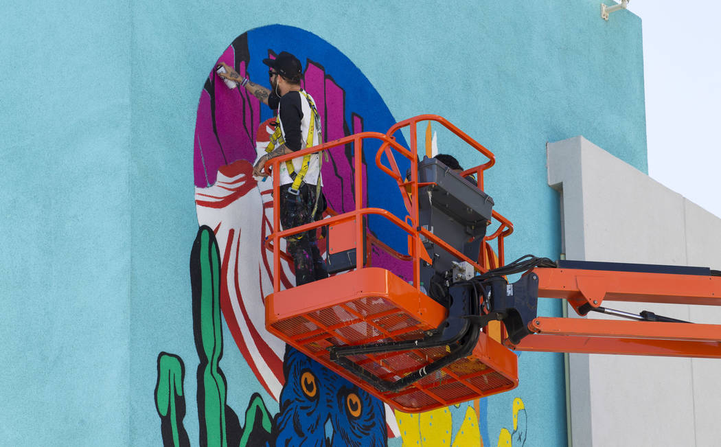 Painters work on a mural on the west side of the El Cortez building as preparations continue on ...