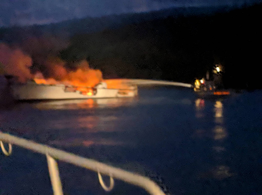 Firefighters work to extinguish a dive boat engulfed in flames after a deadly fire broke out ab ...