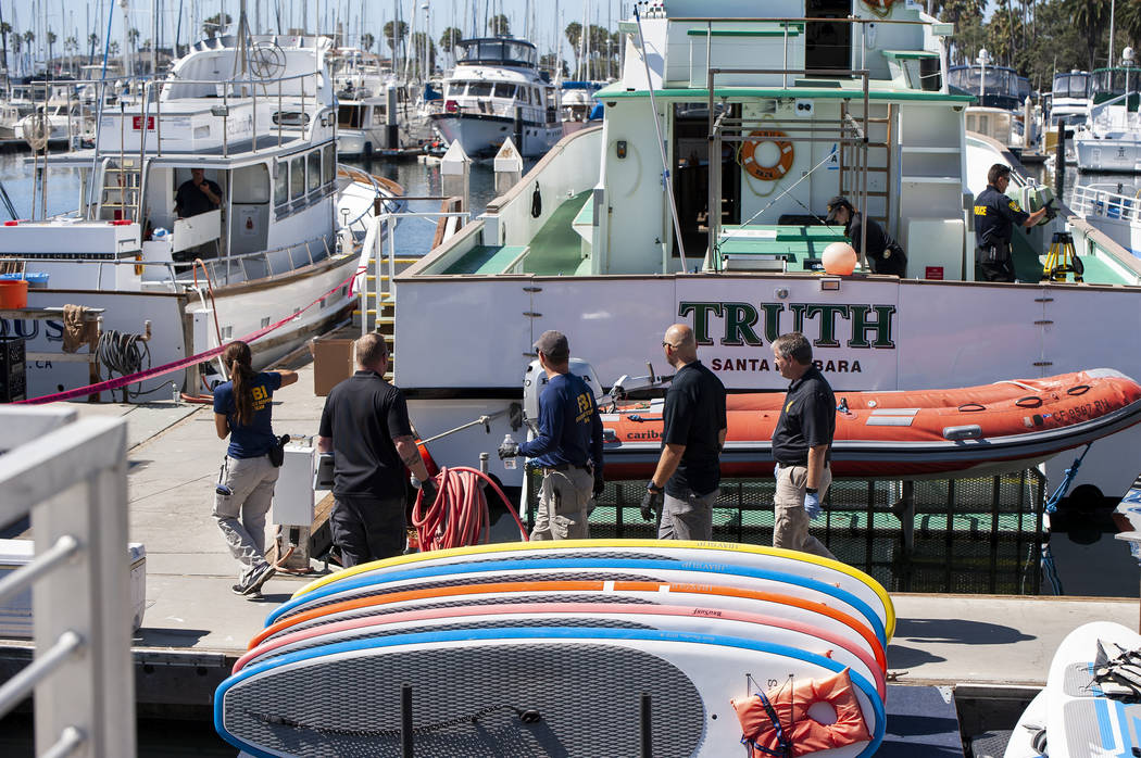 Authorities walk outside the Truth, a Truth Aquatics-owned dive boat, docked in the Santa Barba ...