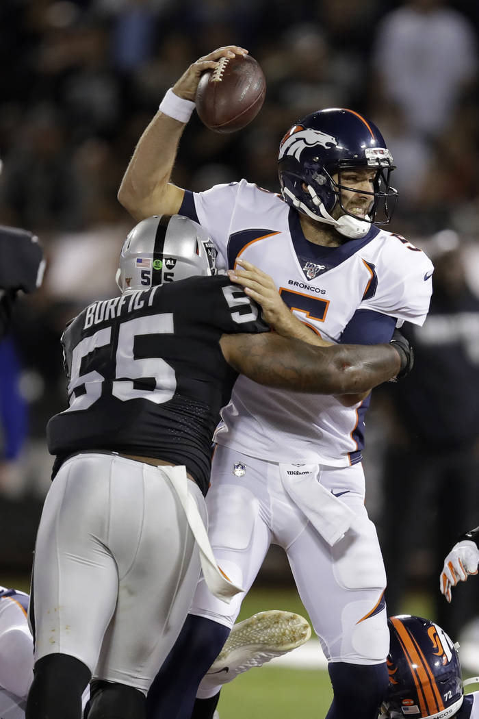 Denver Broncos quarterback Joe Flacco is tackled by Oakland Raiders outside linebacker Vontaze ...