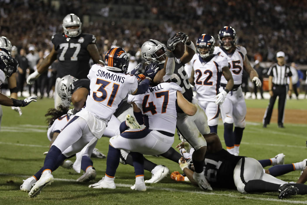 Oakland Raiders running back Josh Jacobs (28) scores a touchdown as Denver Broncos free safety ...