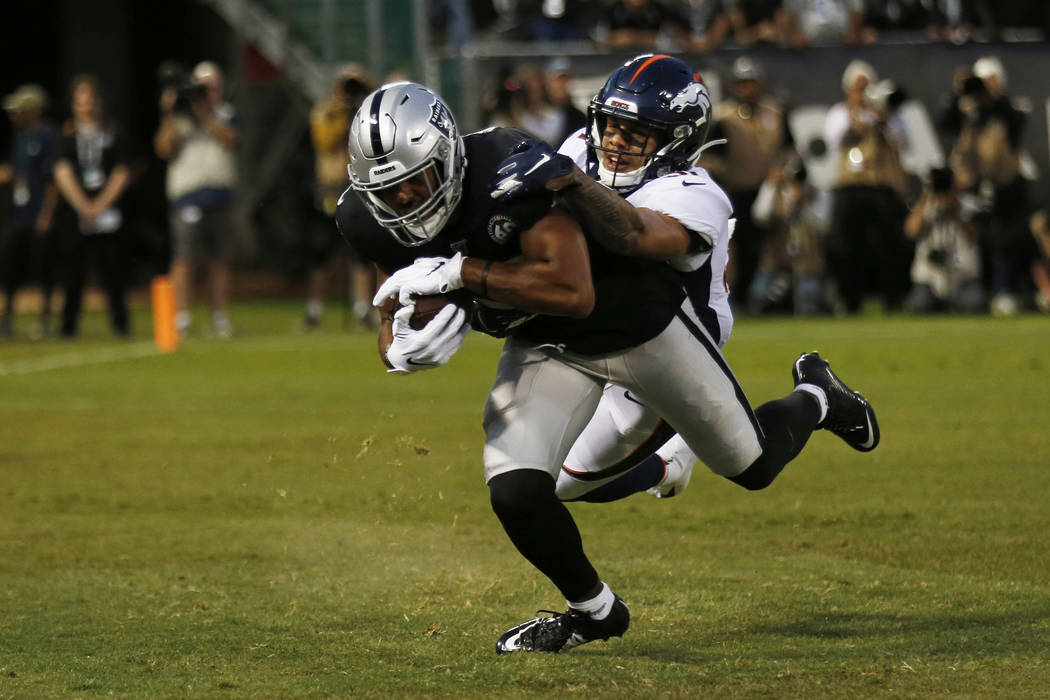 Oakland Raiders wide receiver Tyrell Williams scores a touchdown as Denver Broncos free safety ...