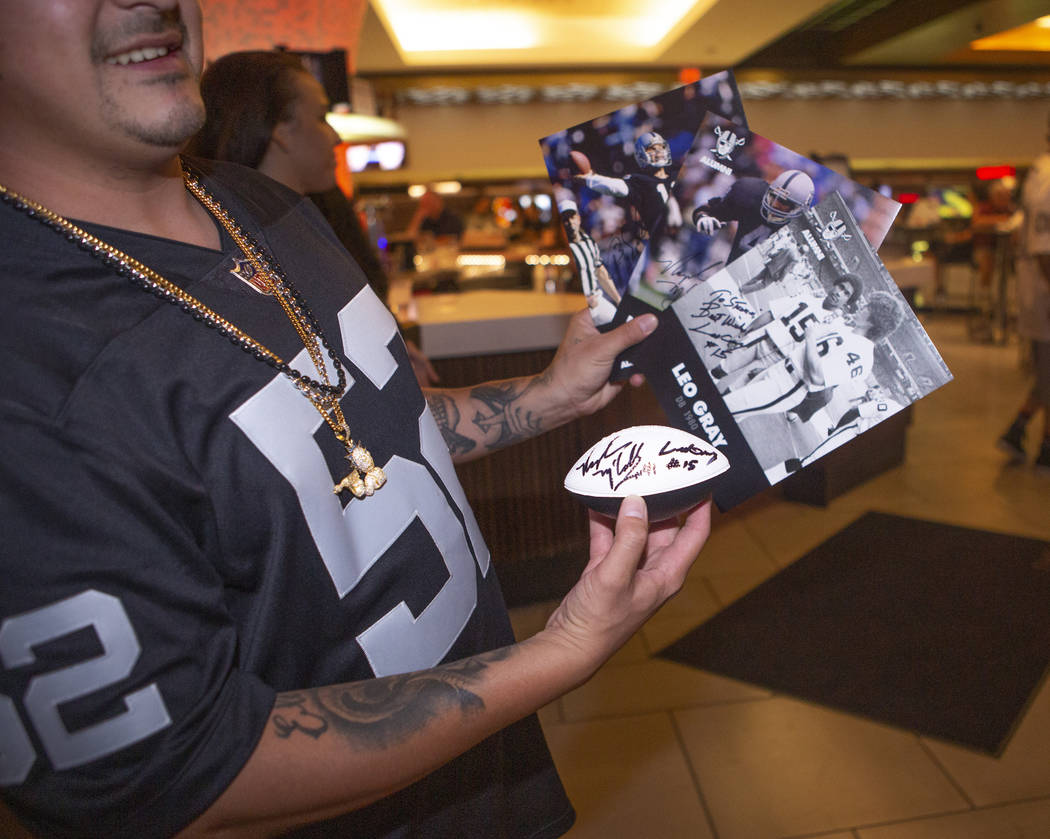 Steven Valtierra, shows off his Oakland Raiders signed cards and football during a fan autograp ...