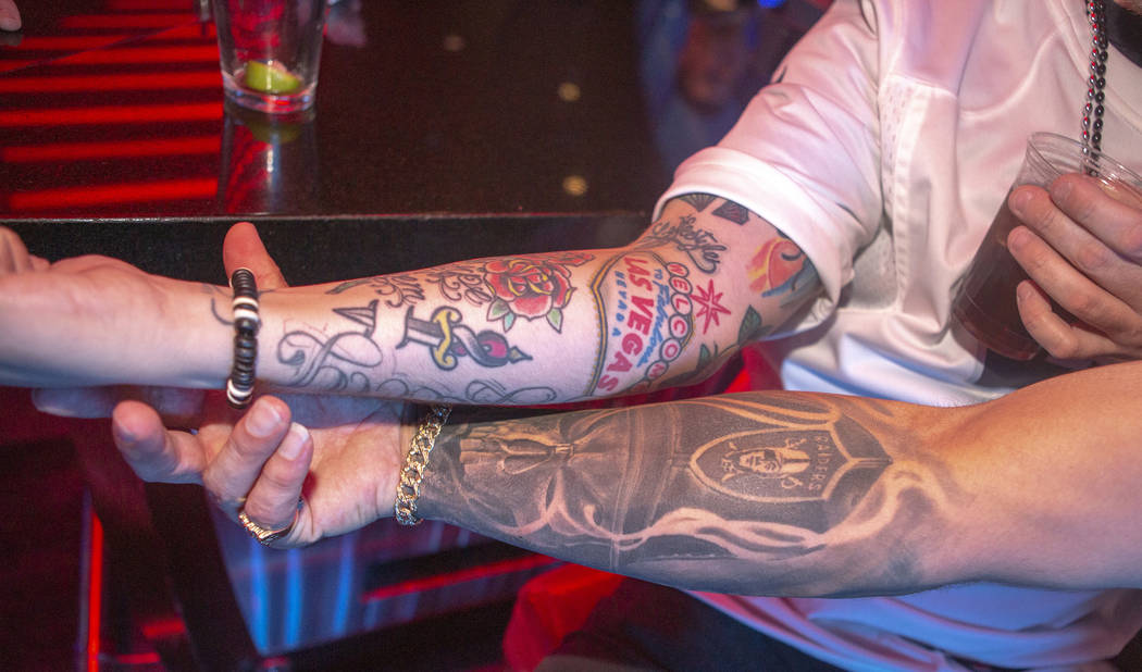 Kevin Petersen, shows his Las Vegas tattoo, as Chad Braden, shows off his Oakland Raiders tatto ...