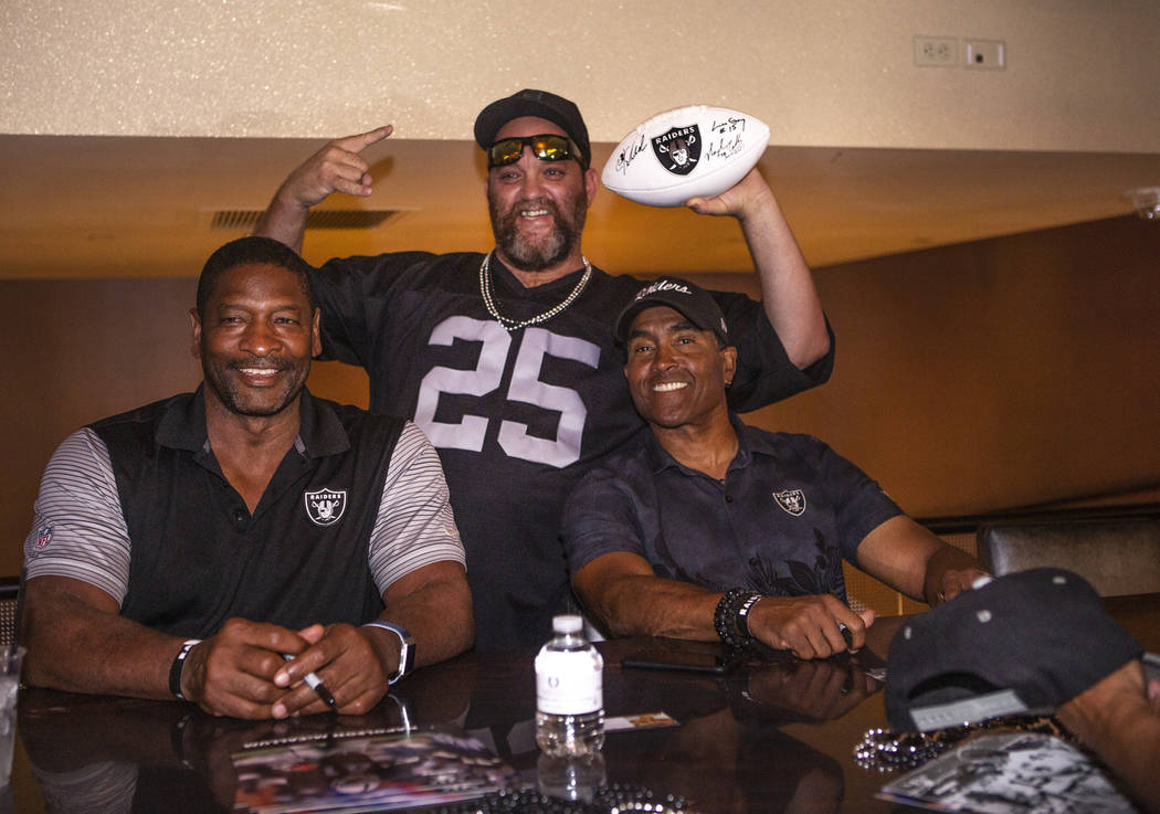 Tom Scannel, poses for a photo with former Oakland Raiders Napoleon Mccallum, right, and Leo Gr ...