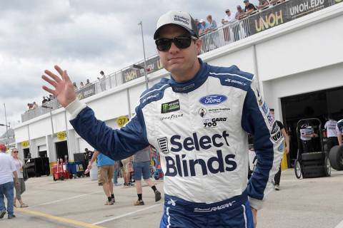 Driver David Ragan waves to fans while walking through the garage area during a practice sessio ...