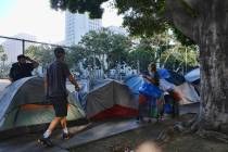 FILE - In this Monday, July 1, 2019 file photo, homeless people move their belongings from a st ...