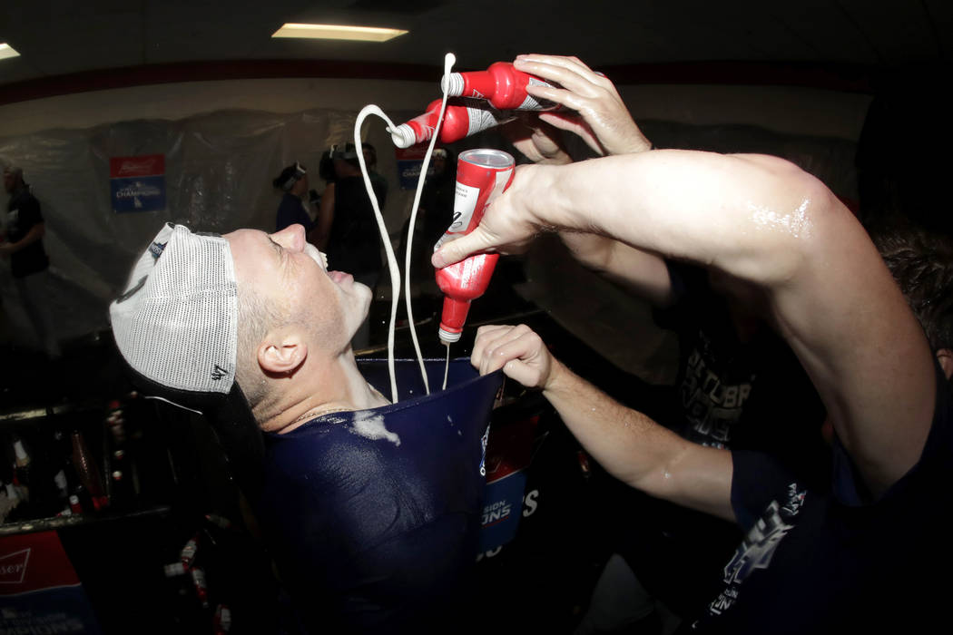 Los Angeles Dodgers second baseman Gavin Lux is doused with beer by teammates during a locker r ...