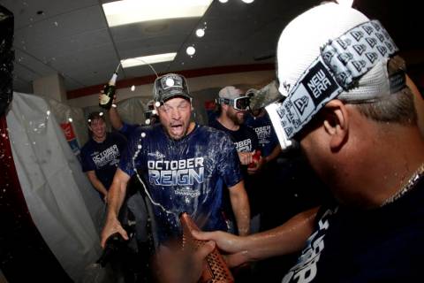 Los Angeles Dodgers pitcher Rich Hill, center, is doused during a lockerroom celebration after ...