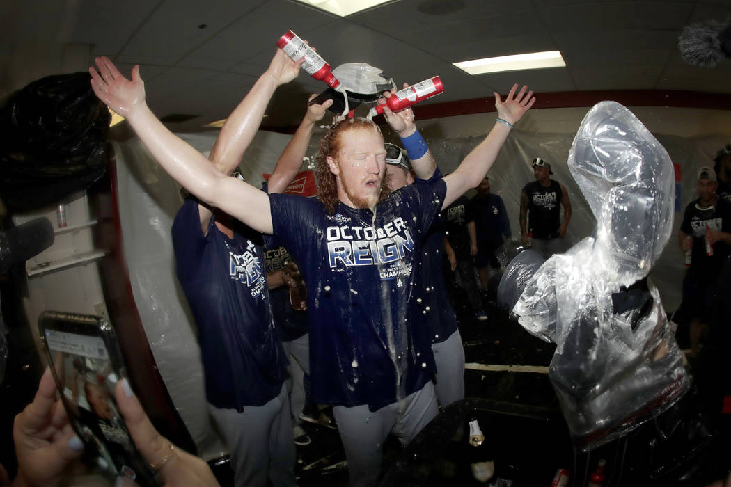 Los Angeles Dodgers pitcher Dustin May, center, is doused during a lockerroom celebration after ...