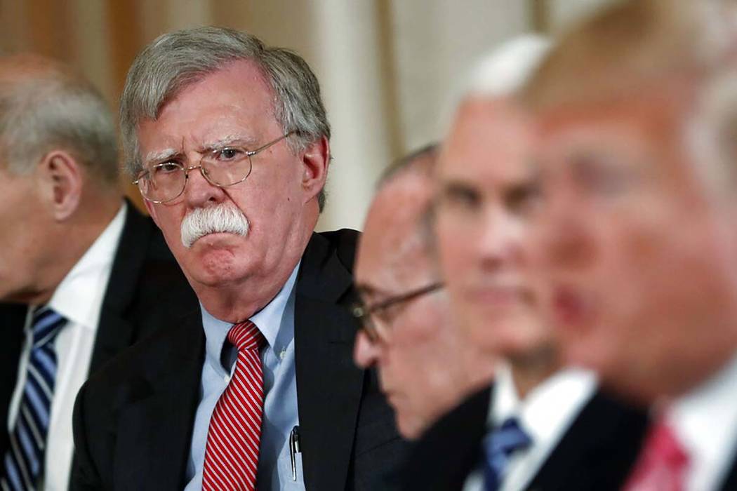 In an April 18, 2018, file photo, National security adviser John Bolton, left, listens to Presi ...