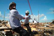 Members of the fire rescue team Task Force 8, from Gainesville, Florida, help remove a body one ...