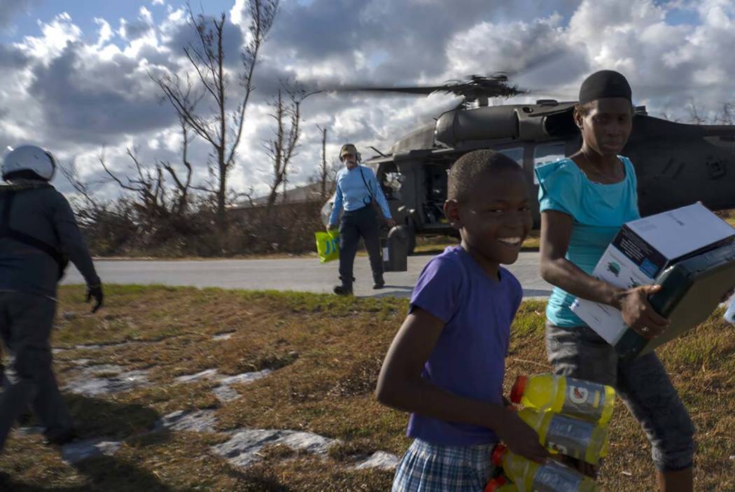 Ayfon Minus, 8, collects donated food that was brought by helicopter from Freeport to the Hurri ...