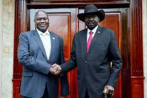 Dr. Riek Machar, left, greets South Sudan President Salva Kiir, right, on his arrival in Juba, ...