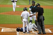 Milwaukee Brewers' Christian Yelich (22) lies on the ground after an injury during an at-bat, a ...