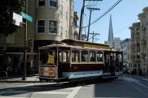 A cable car turns onto Washington Street with the Transamerica Pyramid in the background Wednes ...