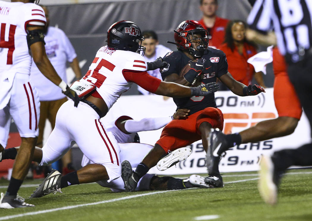 UNLV Rebels running back Charles Williams (8) tries to get past Arkansas State Red Wolves defen ...