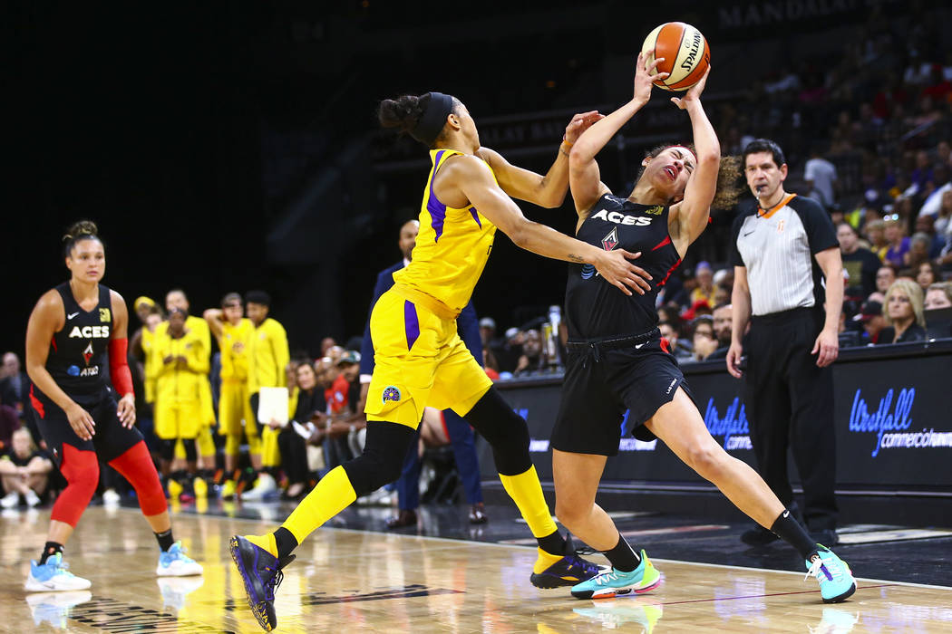 Las Vegas Aces' Dearica Hamby, right, gets fouled by Los Angeles Sparks' Candace Parker during ...