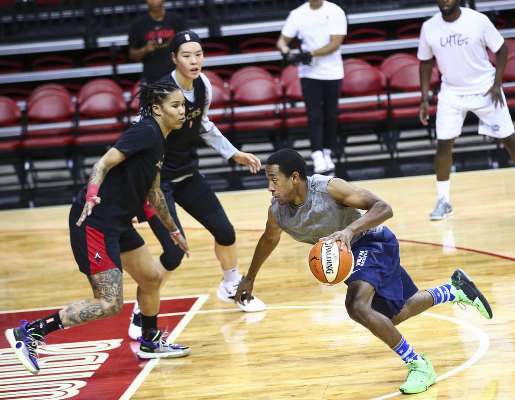 Adrian Dalton drives to the basket against Las Vegas Aces' Tamera Young, left, and Ji-Su Park d ...