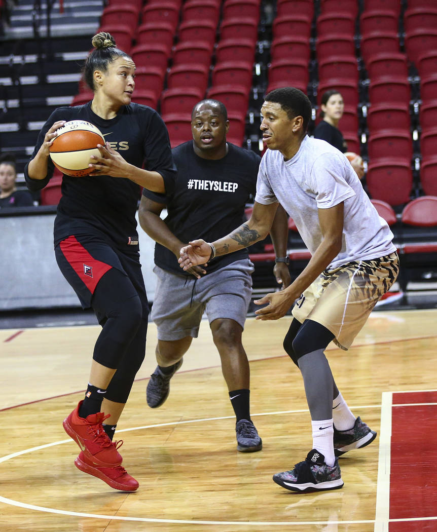 Las Vegas Aces' Kayla McBride, center, looks to pass the ball as Trevill Martin, from left, Dre ...