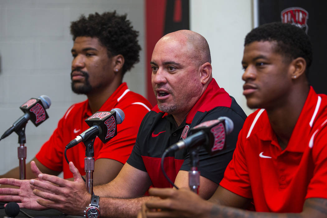 UNLV football head coach Tony Sanchez, center, answers a media question beside quarterback Arma ...