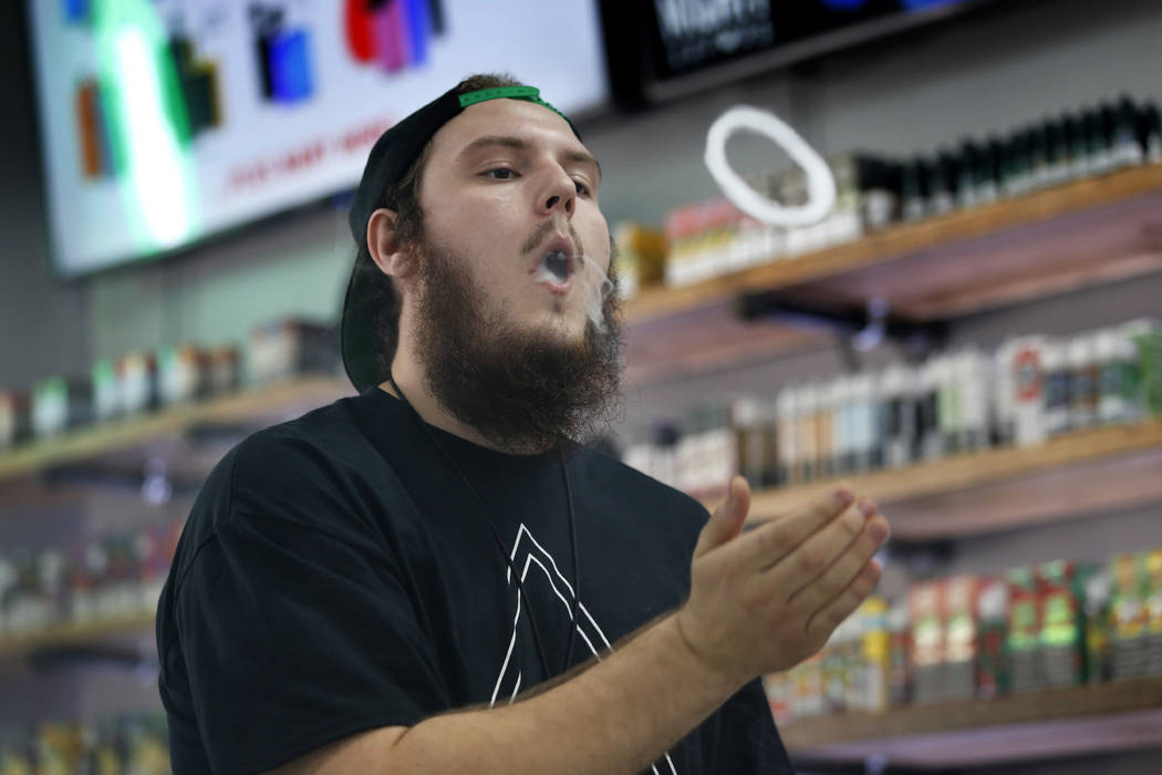 In this Tuesday, Sept. 3, 2019, photo, Devin Lambert, the manager at Good Guys Vape Shop, demon ...