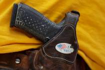 FILE - In this April 14, 2018 file photo, a man wears an unloaded pistol during a pro gun-right ...