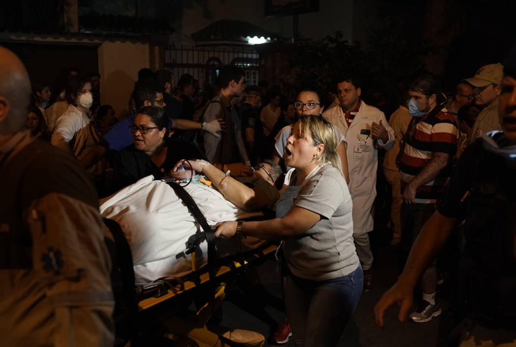 Patients are evacuated from a burning hospital in Rio de Janeiro, Brazil, Thursday, Sept. 12, 2 ...