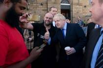 Britain's Prime Minister Boris Johnson poses for a selfie with a member of the publicduring a v ...
