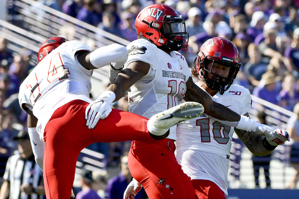 UNLV linebacker Javin White, center, celebrates with defensive back Myles Plummer (14) and line ...