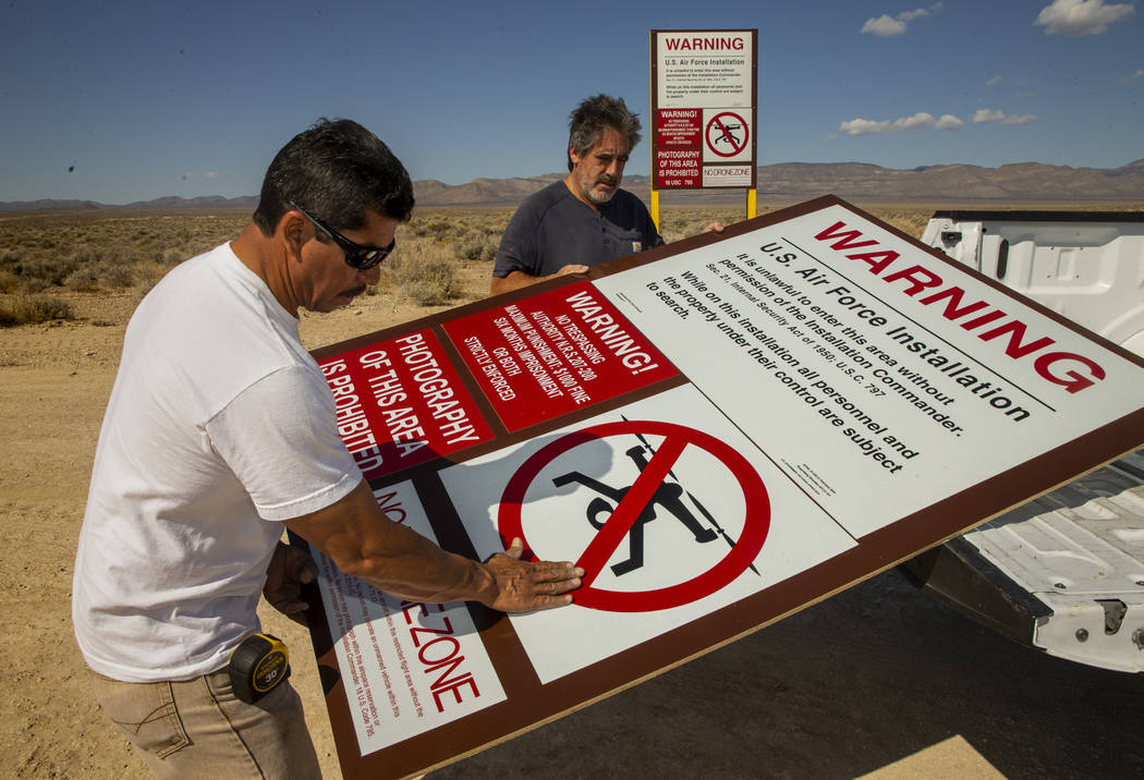 Dean Cruea, right, and Fred Hernandez with The Sign Shop of Las Vegas mount a mock Area 51 main ...