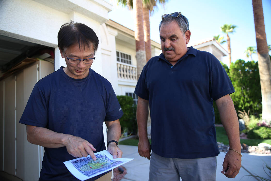 Wayne Niimi, left, in front of the home of his neighbor Victor Padron, shows on a map the three ...