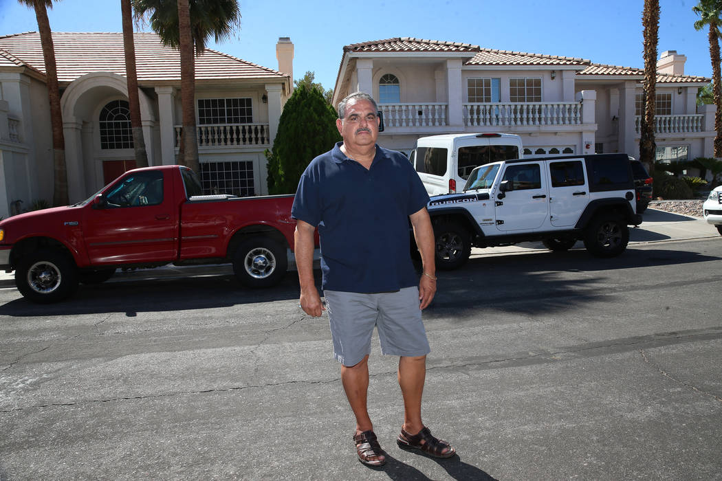 Victor Padron poses in front of his home, left, on Bahama Bay Court in Las Vegas, Thursday, Aug ...