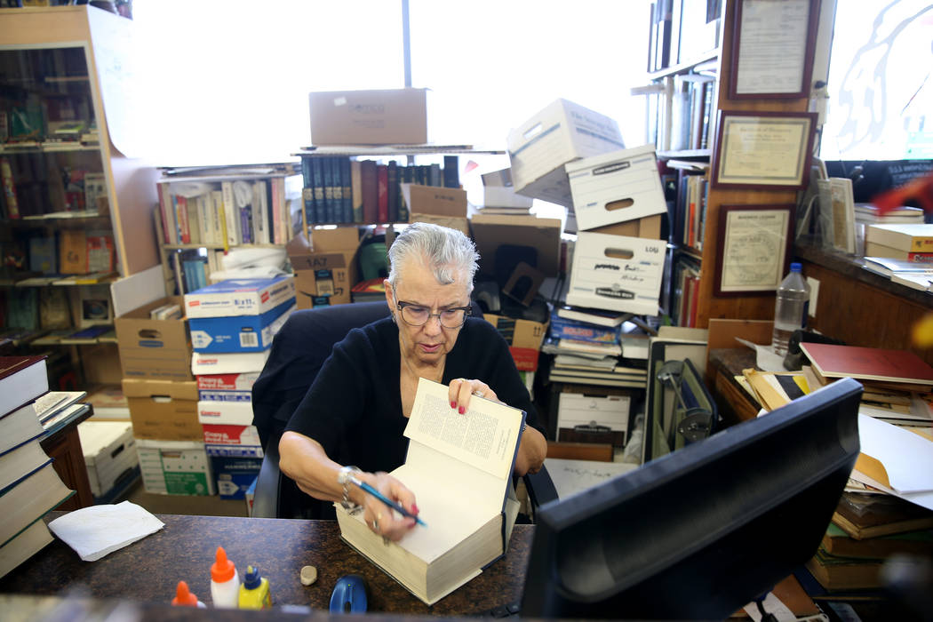 Myrna Donato, owner of Amber Unicorn Books at 2101 S. Decatur Blvd. in Las Vegas, prices a book ...